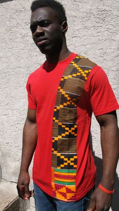 Shipella Men's Kente Striped T- Shirt Bright, bold, beautiful... you This cotton T shirt adds just the right amount of color to show your style and pride. Limited Edition. Size Chart:   Small:     Width 36"   Length 28" Medium: Width 41"   L 29"  Large:     width 44"    L 30" XL:          width 48"    L 34" 2XL:        width 52"    L 32" 3XL         width 56"   L 33" 4XL         width 60"   L 34" PLEASE NOTE: Sizes 3 XL and 4 XL are only available in Red Hebrew Clothing, Panel Shirt, African Print Shirt, Ankara Clothing, African Shirts For Men, King Fashion, African Shirts, African Inspired Fashion, African Men Fashion