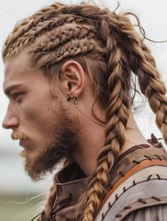 Viking braids offer a bold and rugged hairstyle inspired by Norse warriors. This style involves creating thick, intertwined braids that often run down the back or sides of the head. Viking braids are perfect for themed events, cosplay, or making a strong statement at music festivals. This style suits men with strong, angular face shapes and can enhance light-colored eyes by creating a striking contrast. Vikings Braids Men, Viking Braids Men Long, Warrior Braids Men, Celtic Braids Hair Men, Viking Hair For Men, Nordic Braids For Men, Viking Hair Men Short, Viking Hairstyles Men Long Hair, Viking Hair Male