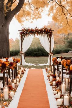 an orange and white wedding aisle with candles