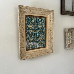 there are two framed pictures on the wall next to each other, one is blue and gold