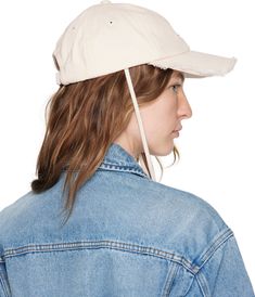 Cotton twill cap in off-white. · Embroidered eyelets at crown · Logo hardware at face · Frayed edge at curved brim · Cord-lock chin strap · Cinch fastening · Logo-engraved silver-tone hardware Part of the Les Classiques collection. Supplier color: Off-white Cream Curved Visor Hat For Spring, Cream Baseball Cap With Curved Visor For Spring, Vintage White Baseball Cap With Curved Brim, White Cotton Baseball Cap For Streetwear, Jacquemus Cap, Jacquemus Hat, Cotton Baseball Cap With Logo Detail, Crown Logo, Silver Engraving