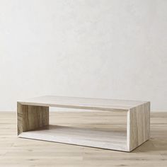 a white coffee table sitting on top of a hard wood floor next to a wall