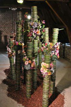 a bunch of vases with flowers on them in the middle of some dirt ground