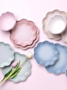 there are many plates that have flowers on the top and one is blue, pink, and white