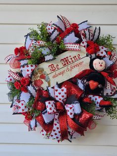 a red and white wreath with a teddy bear on it