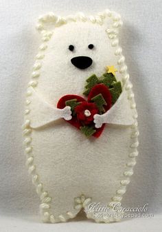 a white teddy bear holding a red heart