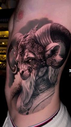 a man's stomach with an artistic tattoo design on it, and the image of a ram