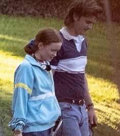 a man and woman walking in the grass