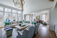 a living room filled with lots of furniture and large windows in the wall behind it