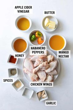 the ingredients for chicken wings are shown on a white plate with bowls and spoons