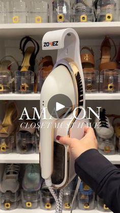 a person is holding an electric hair dryer in front of shelves full of shoes