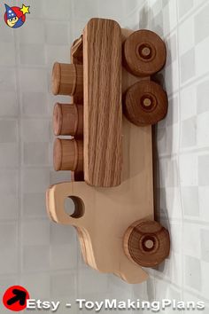 a wooden toy truck is mounted on the wall with pegs to hold it's wheels