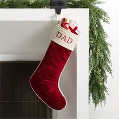 a red christmas stocking hanging from the side of a fireplace with a dad written on it