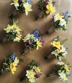 a bunch of flowers that are sitting on a sheet of brown paper with white and yellow flowers in the middle