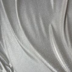 Make a statement with this shimmery silver Lurex Glitter Fabric! This luxurious fabric is perfect for creating stunning gowns, apparel, costumes, party wear, and more. The grey lurex has a two-tone palette/ iridescent look, and is full of glitter, giving it a beautiful shine and sparkle. It stretches on the width side only, and drapes gorgeously, sure to stand out at any event with its beautiful sparkles. The back side of the fabric is white, and made of lurex polyester. Our photographs are as a Glamorous Metallic Shiny Sequin Fabric, Glamorous Metallic Sequin Fabric, Metallic Sequin Fabric With Shimmer For Evening, Metallic Shimmer Sequin Fabric For Evening, Shiny Metallic Sequin Fabric For Evening, Metallic Shiny Sequin Fabric For Evening, Metallic Sequin Fabric With Shimmer For Wedding, Metallic Shimmer Sequin Fabric For Wedding, Fitted Silver Sequin Fabric With Shimmer