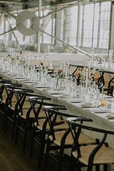 a long table is set up with empty wine glasses