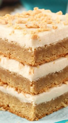 a stack of three pieces of cake sitting on top of a plate with frosting