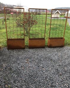 two metal planters sitting on top of gravel