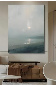 a large painting hanging on the wall in a living room next to a white chair