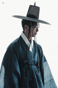 a man with a hat on his head wearing a blue kimono and chain necklace