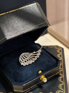 Make a striking impression with this handcrafted angel wing brooch, featuring a captivating wing design adorned with sparkling cubic zirconia. The intricate detailing of the feathers catches the light, giving this brooch a luxurious and sophisticated charm. Whether you're dressing up for a wedding, gala, or simply elevating your everyday style, this elegant brooch is the perfect finishing touch to any outfit. Its sleek design offers both beauty and versatility, ideal for those who appreciate uni Elegant Brooch, Brooch Wedding, Wing Design, Formal Accessories, Wings Design, Cz Jewelry, Everyday Style, Bridal Wear, Angel Wings