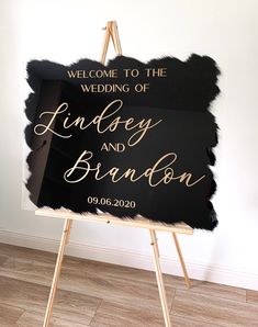 a black and gold wedding sign on a easel