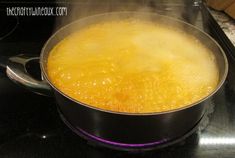 a pan filled with yellow liquid on top of a stovetop next to a burner