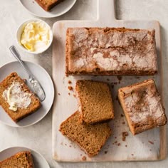 several slices of bread on plates with butter and spoons next to them, along with two bowls of ice cream