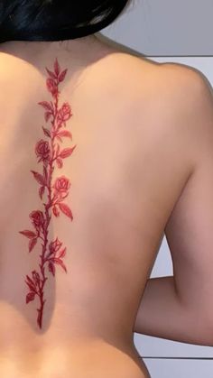 the back of a woman's body with red flowers on her upper and lower back