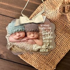 two babies are laying on top of each other in a photo hanging ornament