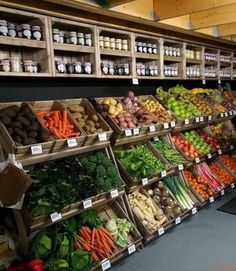 a woman standing in front of a display of fruits and vegetables at a grocery store