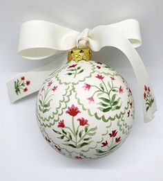 a white ornament with red and green flowers on it