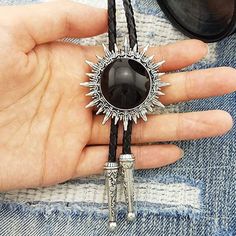 This awesome bolo tie has a southwestern design and black centerpiece.The cord is genuine leather.Our bolos pair nicely with many of our belt buckles! They make wonderful gifts.The western bolo tie rope length is 39'' ; charm pendant size is 1 3/4'' Western Bolo Ties With Adjustable Length, Western Style Concho Lariat Jewelry, Western Style Lariat Jewelry With Concho, Vintage Bolo Ties With Adjustable Length For Rodeo, Adjustable Southwestern Bolo Tie For Western-themed Events, Adjustable Western Bolo Tie With Concho, Concho Lariat Bolo Tie For Western-themed Events, Southwestern Black Concho Jewelry, Black Southwestern Concho Jewelry