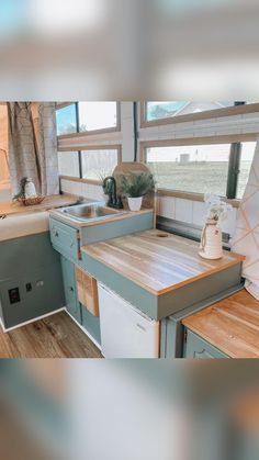 a kitchen area with a sink, stove and counter top next to a large window