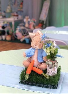 two stuffed animals sitting on top of a table with flowers and carrots in front of them