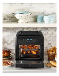 an oven with some food in it and plates on the counter top next to it