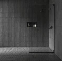 a black and white photo of a bathroom with tiled walls, flooring and shower