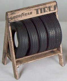 four tires stacked on top of each other in a wooden stand with the word goodyear tire printed on it