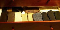 an open drawer filled with lots of different colored shirts and ties on it's sides