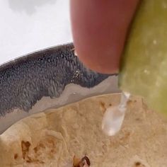 a person is dipping sauce on some tortilla