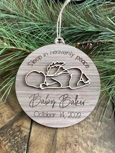 a wooden ornament hanging from a pine tree with the words sleep in heaven