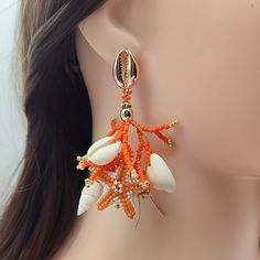 Brighten up your look with these Orange and White Coral Stud Earrings, expertly handcrafted from Japanese Delica beads. Each earring features detailed beaded coral branches and intricately beaded starfish in vibrant orange and crisp white tones. Enhanced with genuine seashells and 18K gold-filled accents, these earrings radiate both luxury and natural beauty. The 18K gold-filled stud closures, designed as delicate seashells, add a sophisticated finishing touch. Ideal for beach lovers and those w Coral Beaded Bohemian Jewelry, Bohemian Beaded Coral Jewelry, Bohemian Beaded Earrings For Vacation, Bohemian Coral Jewelry For The Beach, Bohemian Coral Jewelry For Beach, Coral Bohemian Beach Jewelry, Coral Beaded Earrings For Gifts, Bohemian Dangle Beaded Earrings For Vacation, Bohemian Beaded Coral Earrings