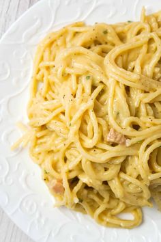 a white plate topped with pasta and meat