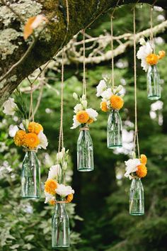 hanging mason jars filled with white and yellow flowers