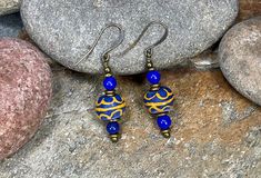 "This pair of African Trade Bead Earrings are designed with blue & yellow Krobo beads from Ghana, Nigerian brass beads, and bronze ear wire hooks. They pair well with many fashion styles and accessorize both day and evening wear! Yes-I can custom design jewelry for you with the African beads I have in stock! Message me about your jewelry desires, and I'll design something just for YOU! I love creating one-of-a-kind jewelry for my clients! COUPON CODES for serious shoppers : Save 10% on purchases totaling $100 or more- enter coupon code 'SAVE10PERCENT' at checkout! Save 15% on purchases totaling $200 or more- enter coupon code 'SAVE15PERCENT' at checkout! Follow my jewelry on Facebook at \"African Echoes Beads\" Follow my creative life on Instagram @rodwimerfineart" Blue Beaded Brass Earrings With Ear Wire, Blue Brass Beaded Earrings With Ear Wire, Blue Beaded Brass Earrings As Gift, Gift Blue Beaded Brass Earrings, Krobo Beads, Small Dangle Earrings, African Earrings, African Trade Beads, Brass Beads