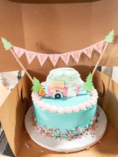 a birthday cake in a box with bunting and decorations