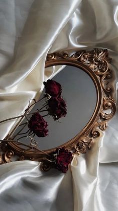 there is a mirror with flowers in it on the bed