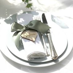 a white plate topped with silverware and a bow