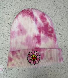 Murakami beanie! This hat magically fits adults and kids and looks adorable on everyone! The hat is dyed with shades of pink and topped off with a pink Murakami flower smiley face patch.  This item has been washed twice, before and after the dying process. Procion fiber reactive dyes are typically color-fast, however, I advise that you wash this freshly-dyed item separately for the first few washes. Pink Murakami Flower, Flower Smiley Face, Smiley Face Patch, Flower Smiley, Murakami Flower, Face Patches, Tie Dye Outfits, Hanukkah Gifts, Custom Ties