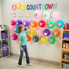 a girl standing in front of a wall with balloons on it